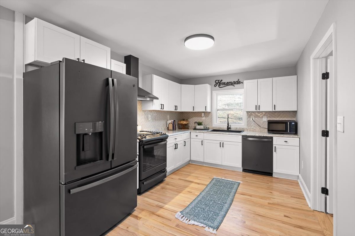 80 Hand Road Bowdon, GA 30108 - Photo 10 of 82 a kitchen with a refrigerator stainless steel appliances wooden floor and cabinets