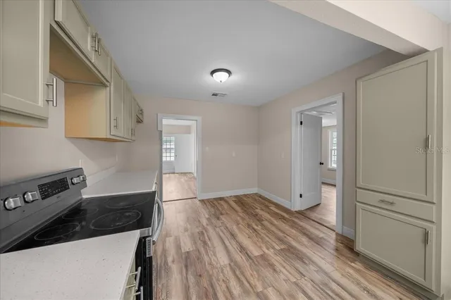 a view of empty room with wooden floor and window