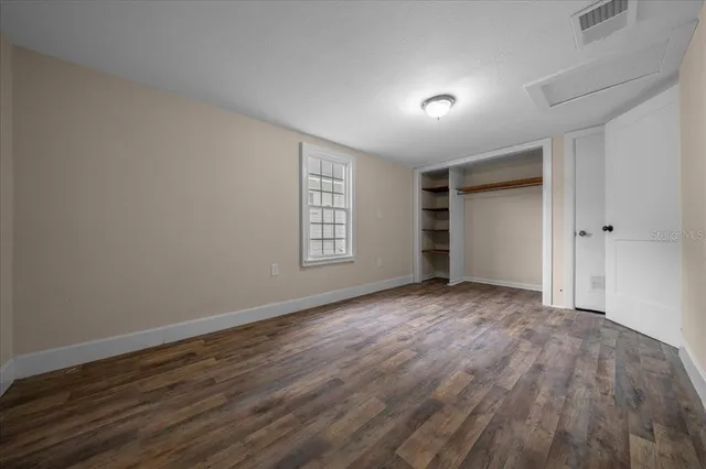 a view of empty room with wooden floor and fireplace