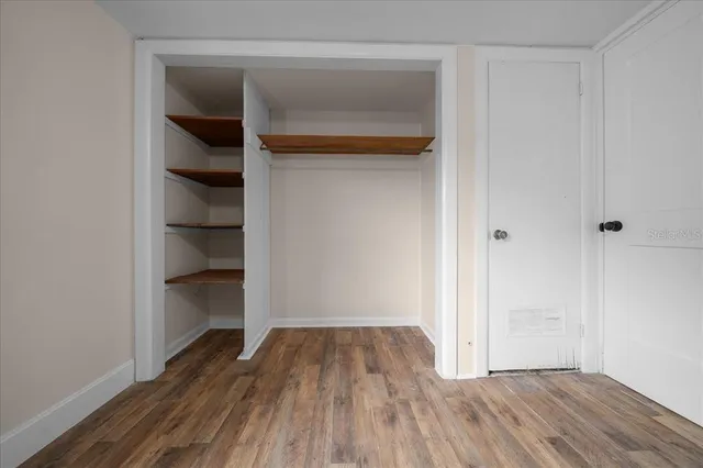 a view of a livingroom with wooden floor and a fireplace