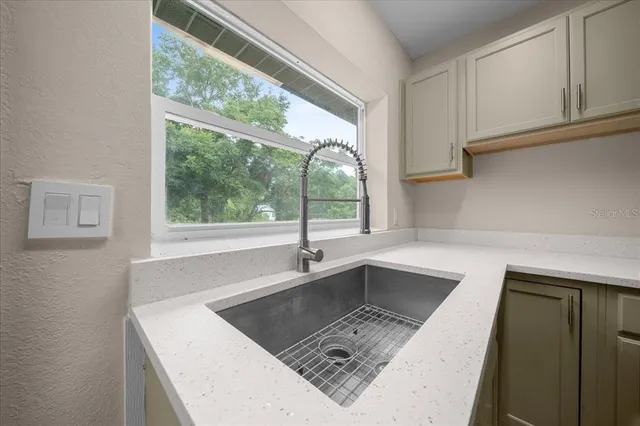 an empty room with windows and fireplace