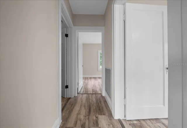 a view of empty room with wooden floor