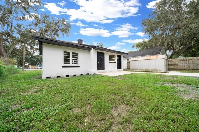 an aerial view of residential houses with outdoor space and trees