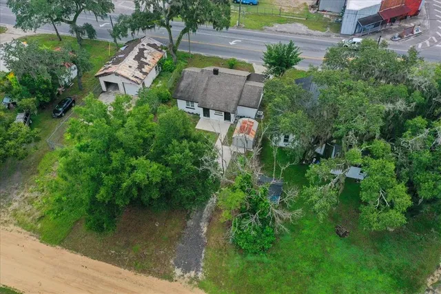 an aerial view of residential houses with outdoor space and trees