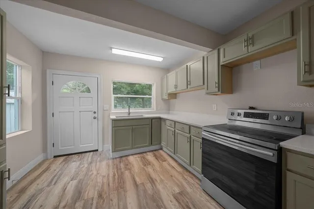 a kitchen with a sink window and a mirror