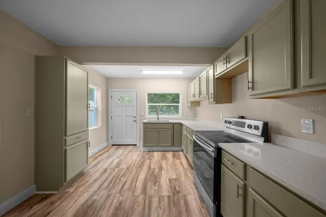 a kitchen with wooden floor and electronic appliances