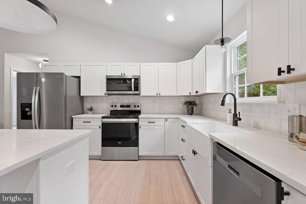 26332 Old Pitts Road Ruther Glen, VA 22546 - Photo 14 of 35 a kitchen with white cabinets and stainless steel appliances