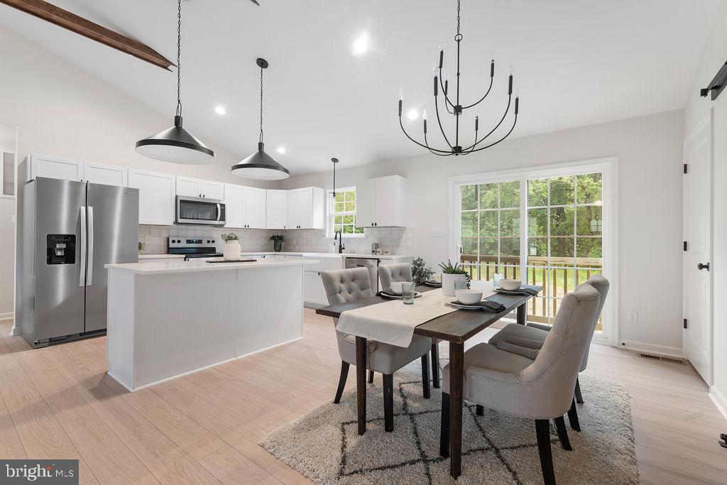 26332 Old Pitts Road Ruther Glen, VA 22546 - Photo 9 of 35 a kitchen with stainless steel appliances granite countertop a sink a stove a refrigerator cabinets a dining table and chairs