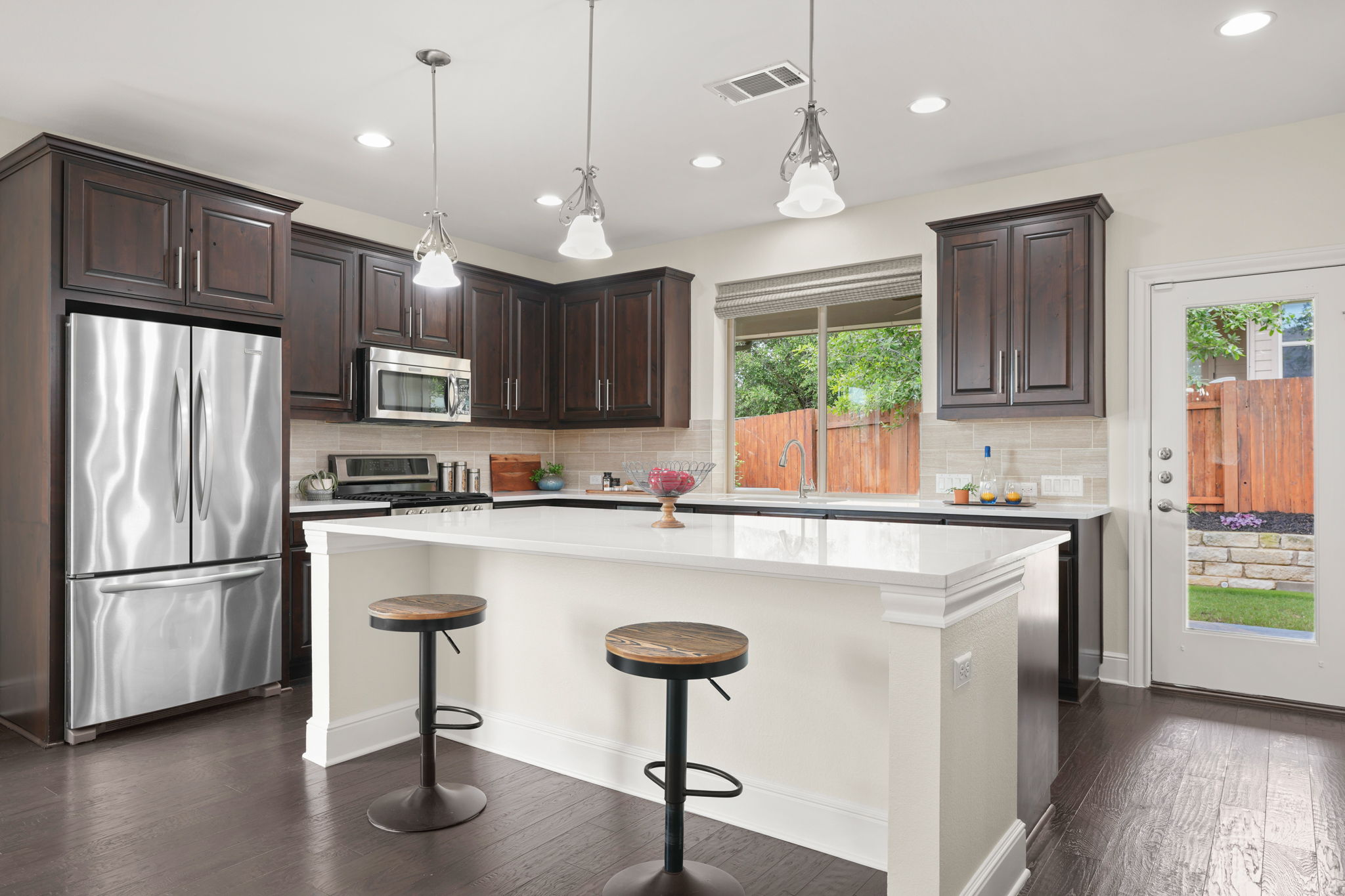440 Cherokee Rose Circle Georgetown, TX 78626 - Photo 20 of 39 A well-lit kitchen with dark wood cabinetry and a functional island for casual dining.