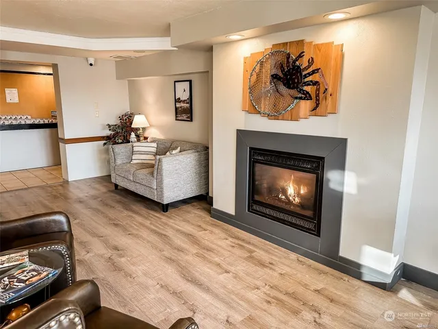 a room with wooden floor pool table and a fireplace