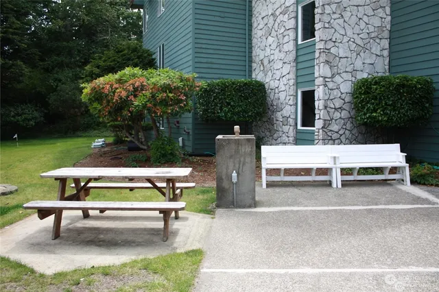 a backyard of a house with barbeque oven table and chairs