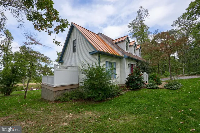 a front view of house with yard and trees in the background