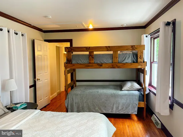a view of a hallway with furniture and wooden floor