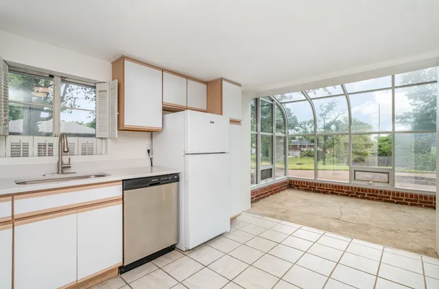 a kitchen with white cabinets and white appliances