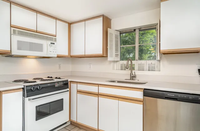 a kitchen with stainless steel appliances granite countertop a sink a stove and a microwave