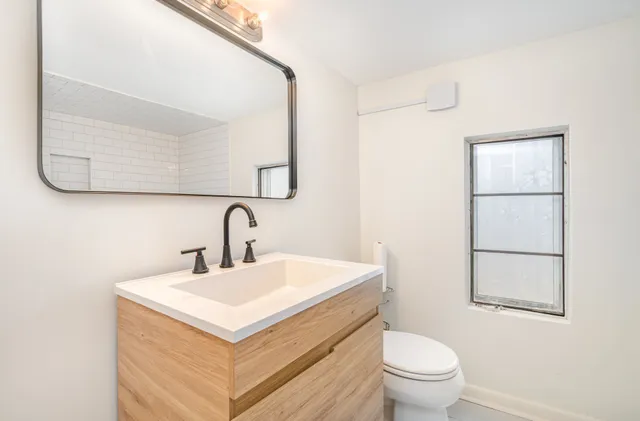 a bathroom with a toilet sink and mirror