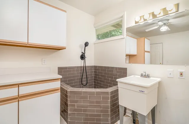 a bathroom with a sink a toilet a mirror and shower