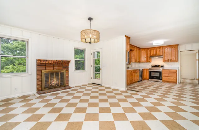 a view of a kitchen with wooden floor and a window