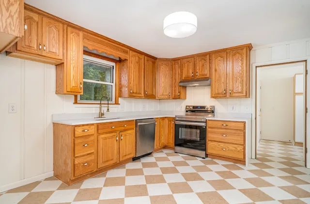 a kitchen with stainless steel appliances granite countertop a stove a sink and a refrigerator