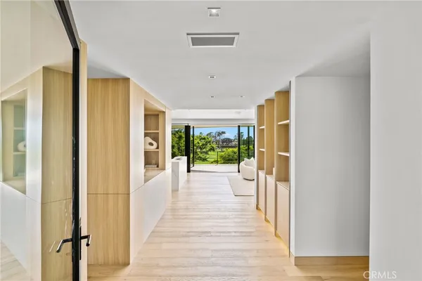 a view of a hallway with wooden floor and windows