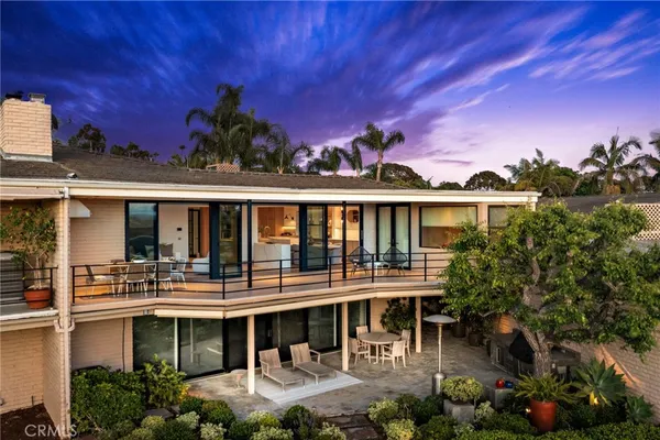 a front view of a house with swimming pool and outdoor seating
