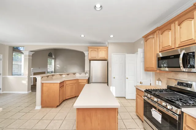 a kitchen with stainless steel appliances granite countertop a stove top oven a sink dishwasher and a refrigerator