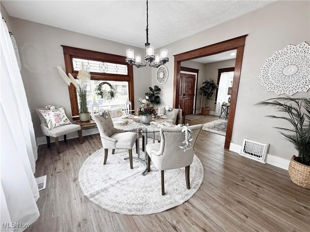 281 Sexton Street Struthers, OH 44471 - Photo 8 of 28 Dining space with light wood finished floors, a chandelier, and a textured ceiling