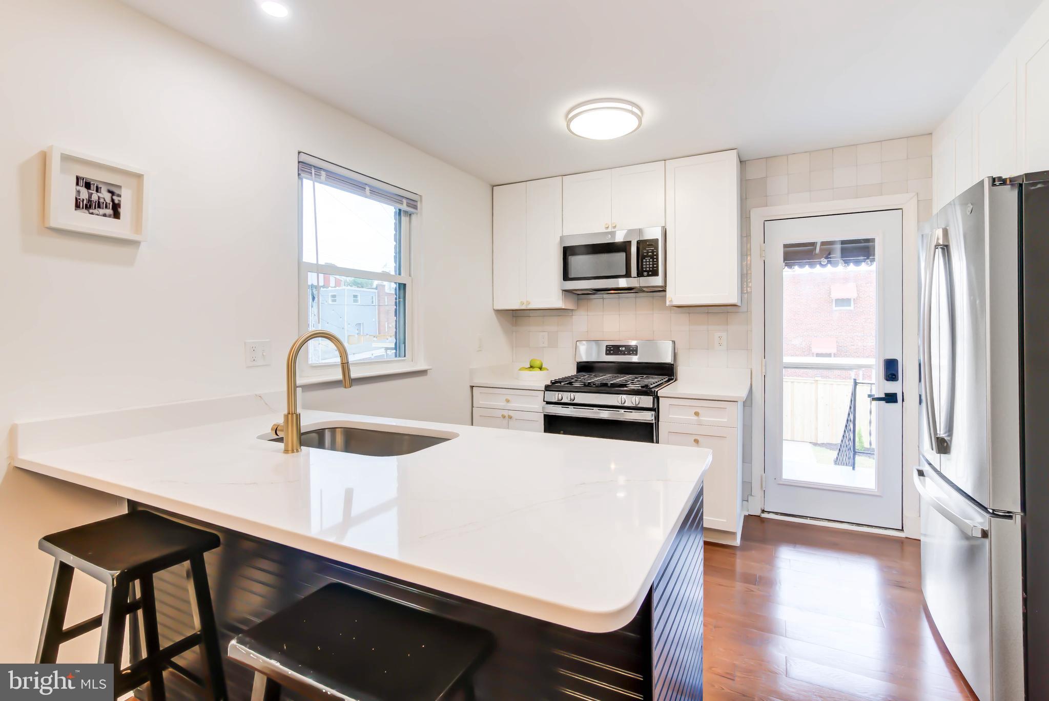 459 Riggs Road Northeast Washington, DC 20011 - Photo 19 of 57 a kitchen with stainless steel appliances a stove a sink and a refrigerator
