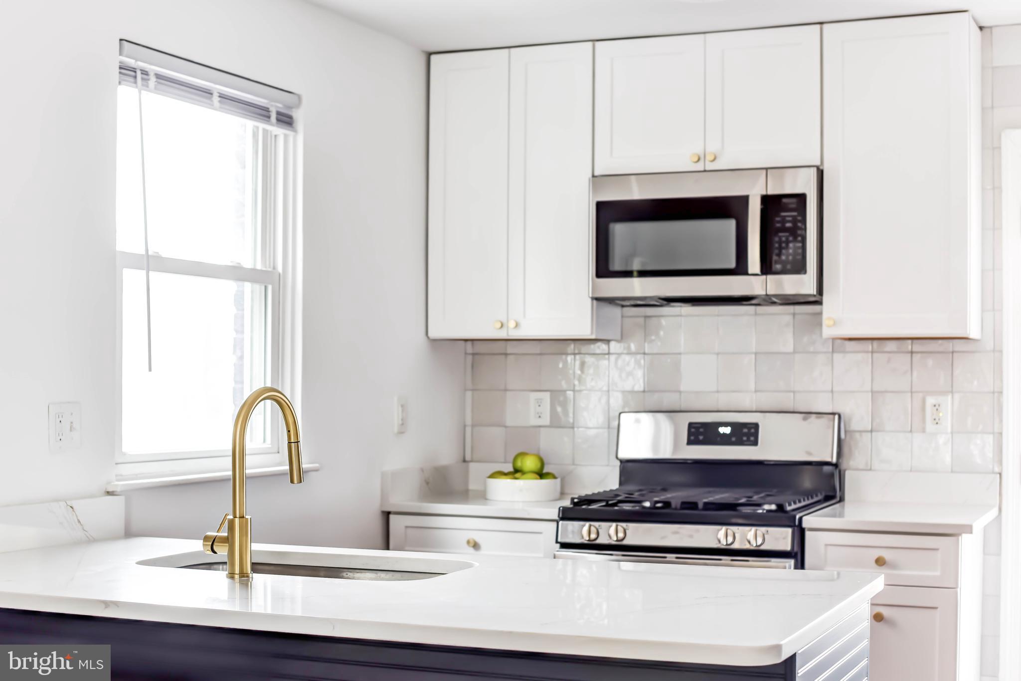 459 Riggs Road Northeast Washington, DC 20011 - Photo 21 of 57 a kitchen with stainless steel appliances a stove a microwave and sink