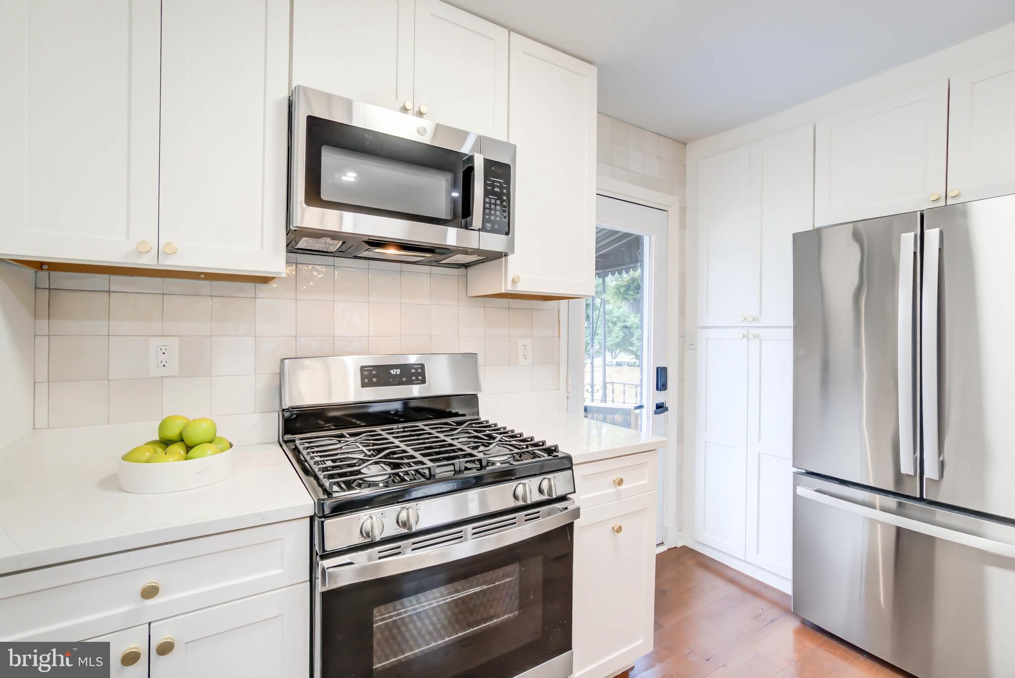 459 Riggs Road Northeast Washington, DC 20011 - Photo 22 of 57 a kitchen with stainless steel appliances a stove a microwave and cabinets