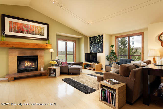 a living room with furniture large window and a fireplace
