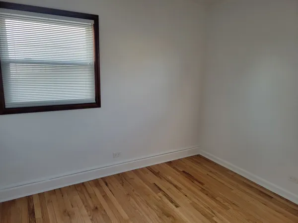a view of a small space with wooden floor and a window
