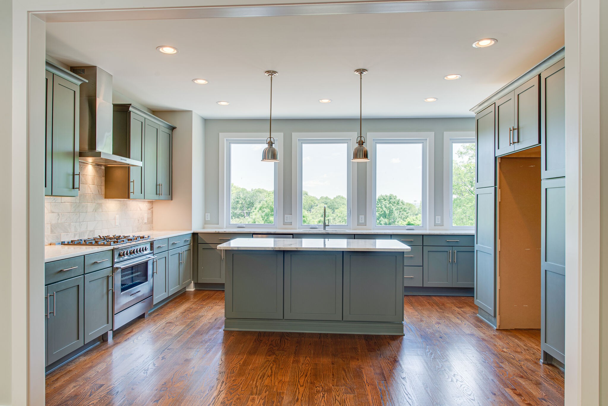 119 Demoss Road Nashville, TN 37209 - Photo 10 of 38 a kitchen with kitchen island granite countertop a stove a sink a refrigerator wooden floor and cabinets