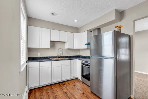 a kitchen with stainless steel appliances granite countertop a refrigerator and a stove top oven