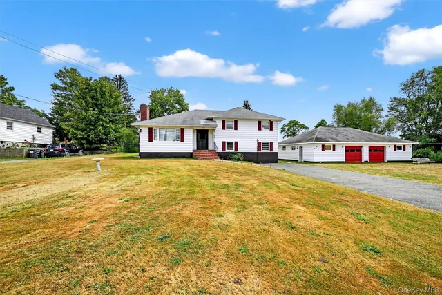 a aerial view of a house with swimming pool and next to a yard