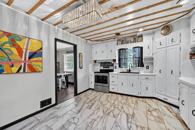 a large white kitchen with stainless steel appliances granite countertop a refrigerator and a stove top oven