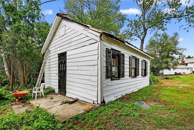 a view of house with backyard and sitting area