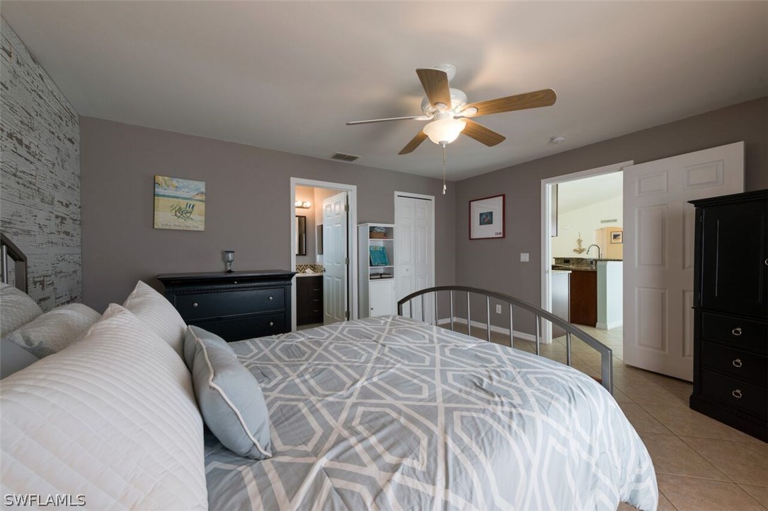 7274 Myrtle Road Fort Myers, FL 33967 - Photo 16 of 25 a bedroom with a bed and a large mirror with a flat tv screen