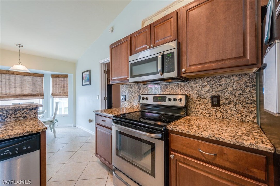7274 Myrtle Road Fort Myers, FL 33967 - Photo 6 of 25 a kitchen with stainless steel appliances granite countertop a stove microwave and cabinets