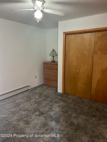 a view of a room with a ceiling fan and window