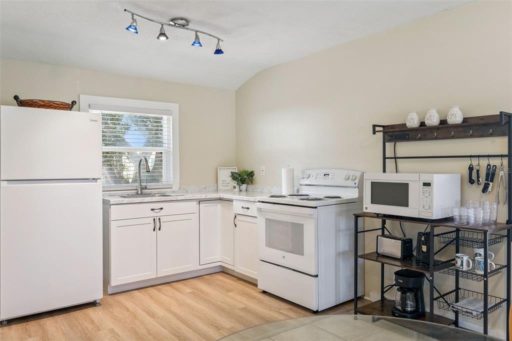 5108 South Ridgewood Avenue Port Orange, FL 32127 - Photo 12 of 44 a kitchen with a stove a sink and white cabinets