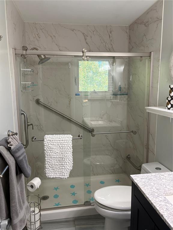 14531 Walsingham Road, Unit 224 Largo, FL 33774 - Photo 40 of 41 a bathroom with a granite countertop sink toilet and shower