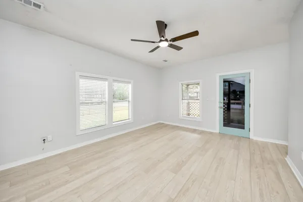 wooden floor in an empty room with a kitchen
