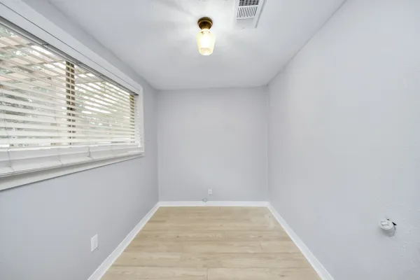 a bathroom with a toilet a sink a light fixture and a window