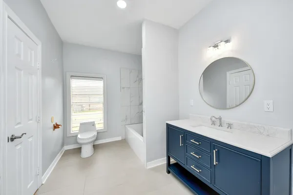 an empty room with windows and ceiling fan