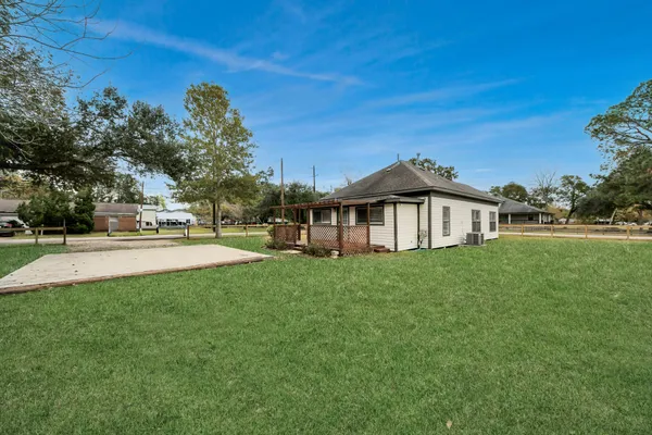 a view of a house with a big yard and large trees
