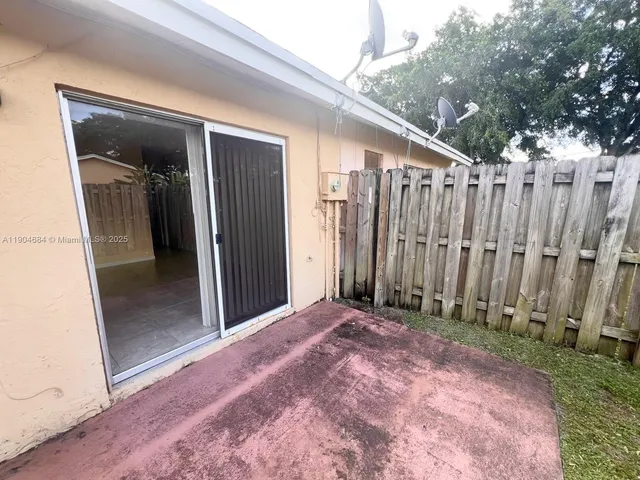 a view of a backyard with wooden fence