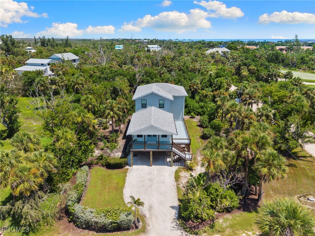 a aerial view of a house with a yard and lake view