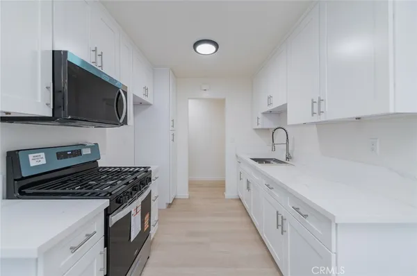 a kitchen with stainless steel appliances a sink stove and microwave