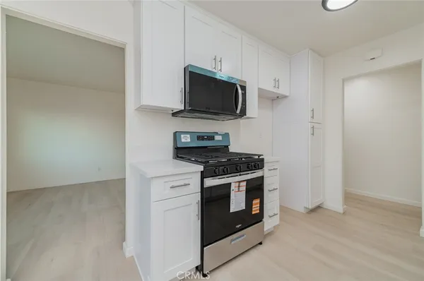 a kitchen with stainless steel appliances granite countertop a stove and a microwave
